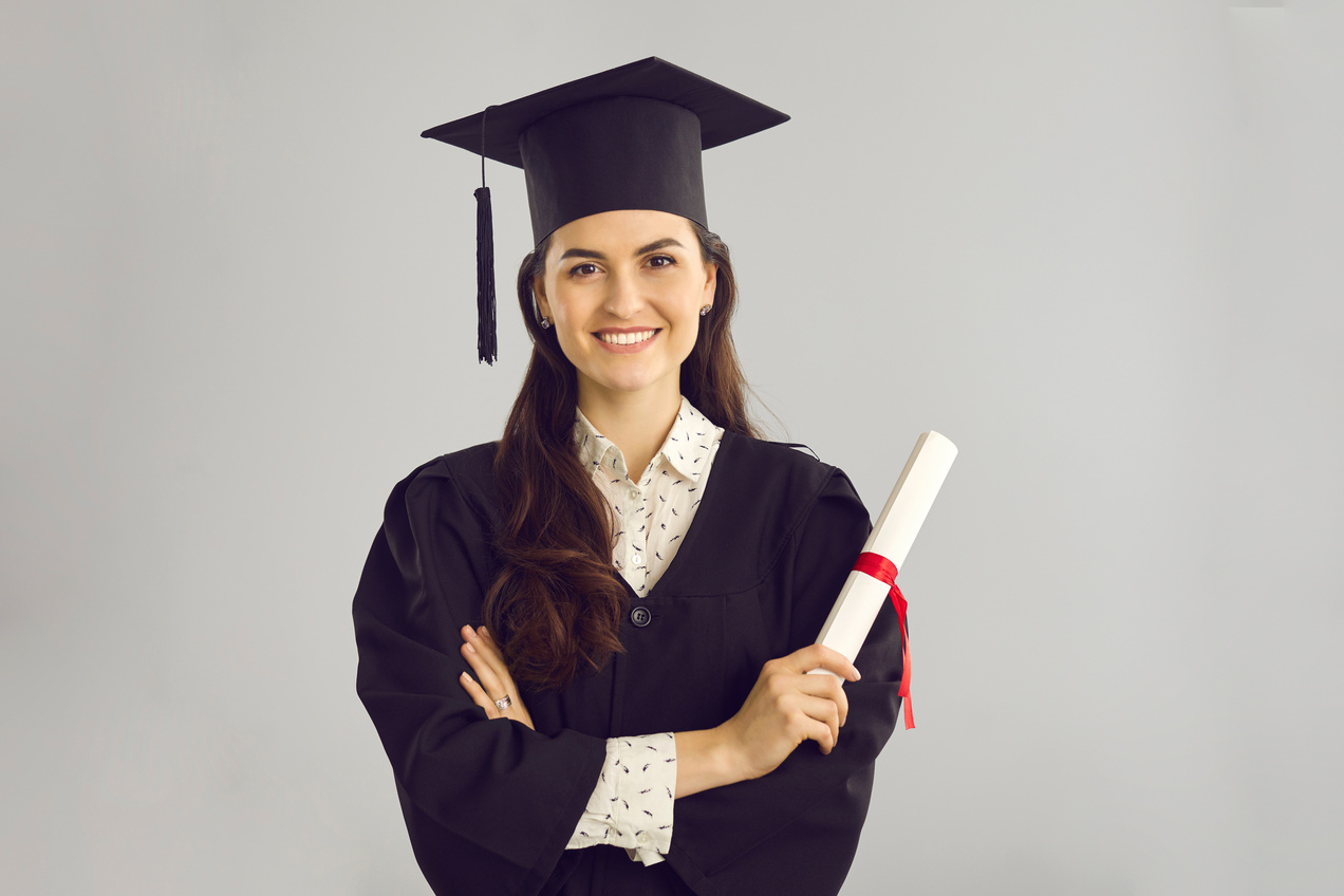 Studio Portrait of Happy Smart College Graduate Holding Her Diploma and Smiling at Camera